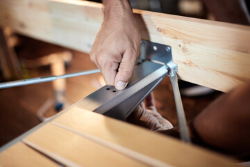 Carpenter hobbyist assembling wooden boards at home / garage.