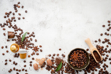 Background of various coffee , dark roasted coffee beans , ground and capsules with scoops setup on white concrete background with copy space.