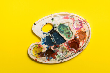 dirty palette  on a yellow background. place for text. children's creativity.