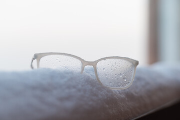 Women's glasses with white frames on the snow