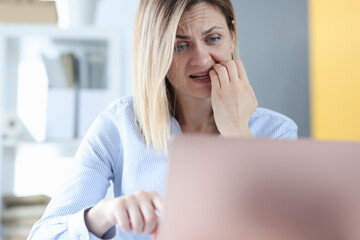 Frightened woman looks into laptop monitor closeup