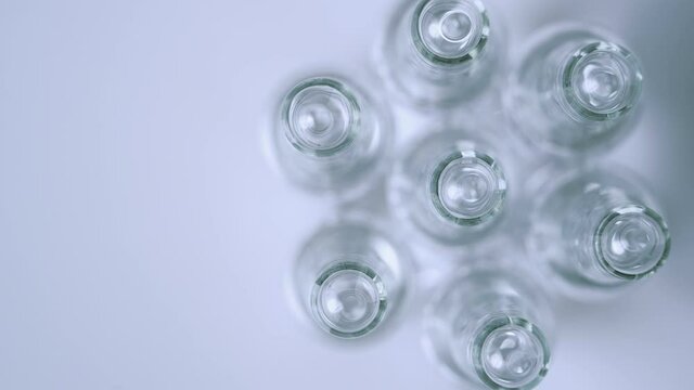 Transparent ampoules with vaccine rotate, top view. Coronavirus, COVID-19, SARS-COV-2 vaccine