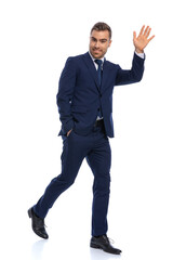 full body picture of happy businessman holding hand up and waving
