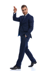 attractive bearded guy in navy blue suit looking to side and saluting
