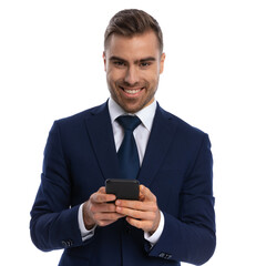 cheerful happy man in elegant suit texting messages and laughing