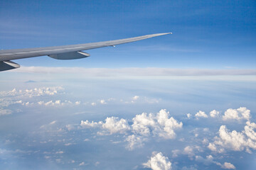 Wing of the plane on blue sky background. Aerial view of Blue sky and Cloud Top view from airplane window,Nature background. Sky and clouds. airplane wing