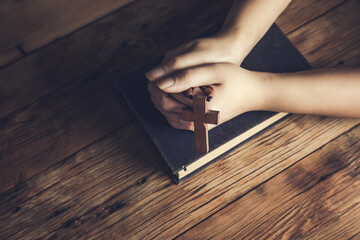 woman holding cross on Bible
