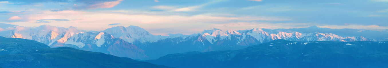 Fototapeta na wymiar Large panorama. Mountain peaks in the sunset light.
