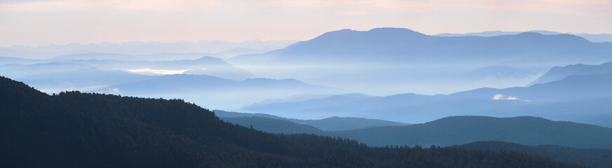 Obraz premium Beautiful sunrise in the mountains, panorama landscape. Morning haze, fog.