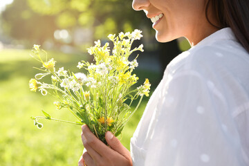 Young woman with beautiful bouquet outdoors on sunny day, closeup