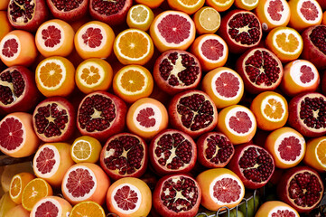Pomegranates, cut lemons showing their segments with intense yellow and red colors