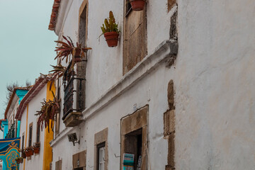 Fototapeta na wymiar OBIDOS, PORTUGAL - 08-09-2020 : Souvenir shops and colorful narrow streets of the medieval portuguese city of Óbidos, a tourist attraction in central Portugal. famous destination for its architecture