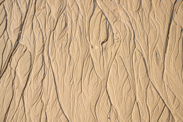 water has left abstract traces in the sand, as design element or background with copy space