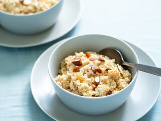 Quinoa porrige on tabletop. Two bowl wit quinoa milk porridge with berries and almond