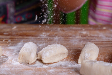 Close up female pastry chef preparing dough on wooden board.