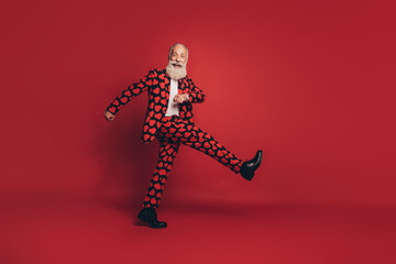 Photo of funny positive gentleman walk march look camera wear heart print suit footwear isolated red background