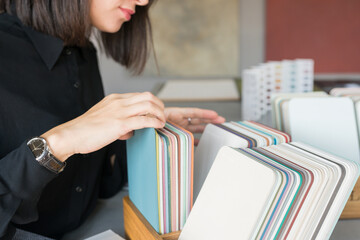 Young woman choosing materials for home renovation. interior designer looking at color samples for...