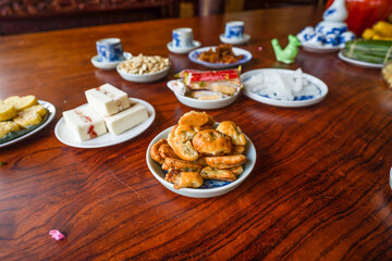 View of Vietnamese food for Tet holiday in spring, jam is traditional food and teapot set on lunar new year. Dried fruit and jam as tradition dessert - Mut Tet on wooden table.