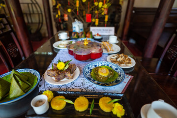 View of Vietnamese food for Tet holiday in spring, jam is traditional food and teapot set on lunar new year. Dried fruit and jam as tradition dessert - Mut Tet on wooden table.