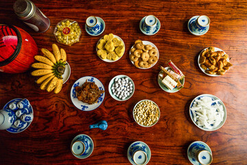 View of Vietnamese food for Tet holiday in spring, jam is traditional food and teapot set on lunar new year. Dried fruit and jam as tradition dessert - Mut Tet on wooden table.