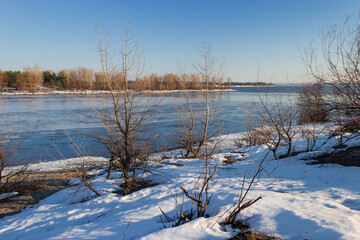 Plain river partially covered with ice in early spring