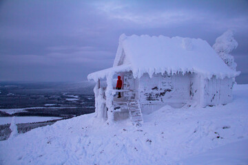Hidden Santas cottage covered in snow in the ski slopes on the mountain at Levi ski center,...
