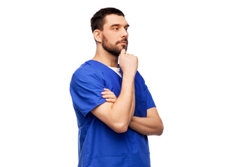 healthcare, profession and medicine concept - thinking doctor or male nurse in blue uniform over...