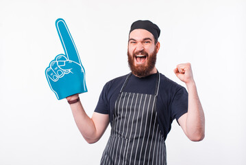Photo of chef man celebrating and pointing with fan foam glove.