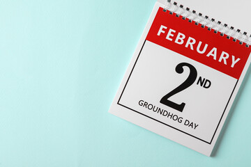 Top view of calendar with date February 2nd on light blue background, space for text. Groundhog day