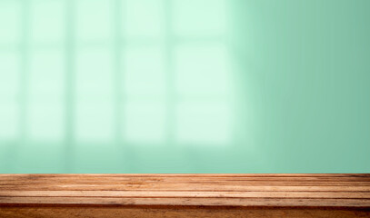 Empty table top made of natural wood, light.rays from the window on the background of the wall. For product demonstration