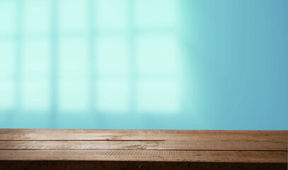 Empty table top made of natural wood, light.rays from the window on the background of the wall. For product demonstration