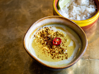 Yellow curry with cauliflower and chickpea and rice on metal tabletop background. Indian food....