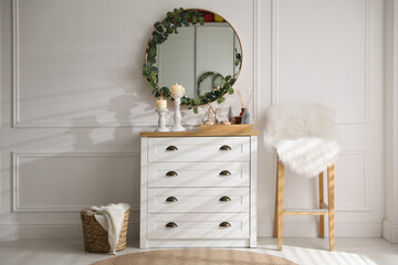 Modern room interior with chest of drawers and mirror on white wall
