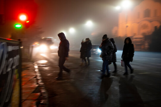 Busy city street people on zebra crossing at night. Dangerous situation