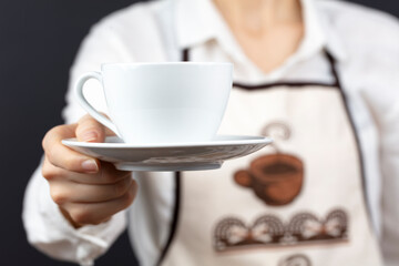 coffee time. A waiter holding and serving a glass of hot coffee isolated on a black background.

