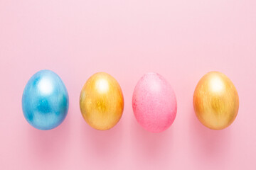 Multi-colored Easter eggs on a pink isolated background. Easter is a bright holiday.