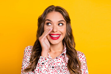 Photo of cunning curious girl palm mouth look empty space wear heart print shirt isolated yellow color background