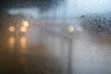 Rain on a window with road trafic in the background