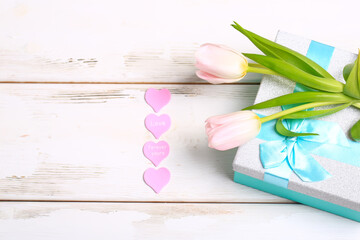 pink tulips with gift box on white wooden background. Valentine day romantic background.
