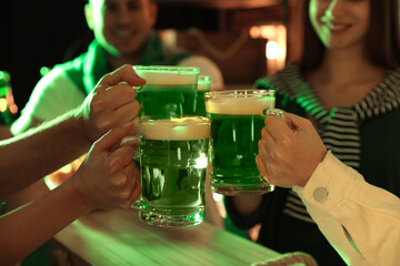 People with beer celebrating St Patrick's day in pub, closeup