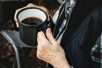 Having coffee by the tent in the forest