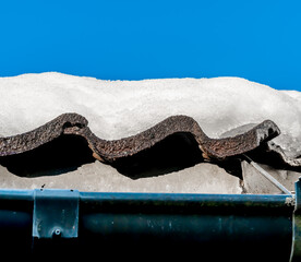 Melting snow on the roof of a house. Close up.