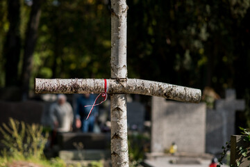 The white and red Polish flag on the grave of the cross in the cemetery