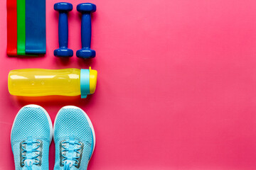 Fitness and gym equipment with sneakers and dumbbells. Sport background
