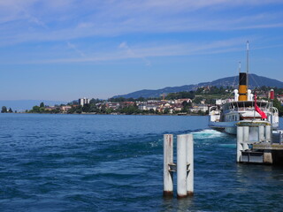 MONTREUX, SWITZERLAND on JULY 2017: Steam boat sails away at pier on Leman Lake in european city in...