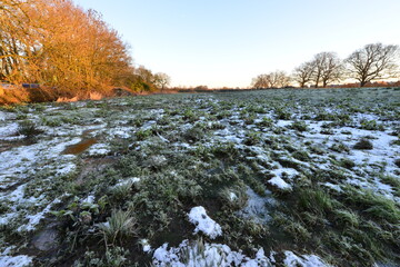 Frozen Icy water on a flood plain in Horley, Surrey, UK in January 2021