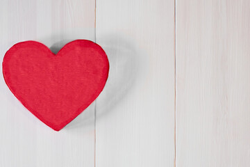 Top view. Love symbol big red heart on a light pink wooden background with space for text. Valentine's day concept. Selective focus.