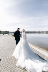 Fototapeta na wymiar Bride and groom on their wedding day near the river. Classic wedding portrait