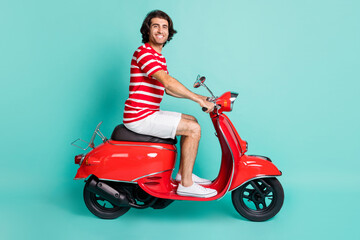 Fototapeta na wymiar Profile side view portrait of handsome cheery guy driving moped highway isolated over bright green turquoise color background