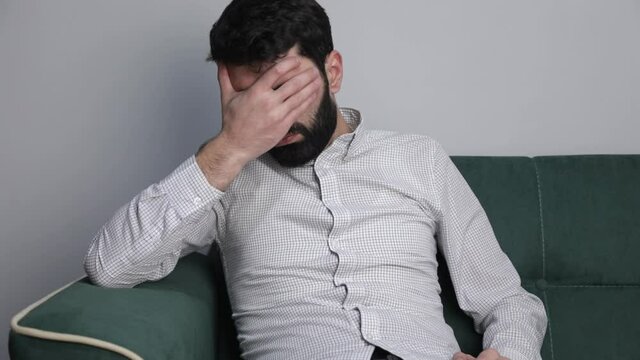 Sad male suffering from headache